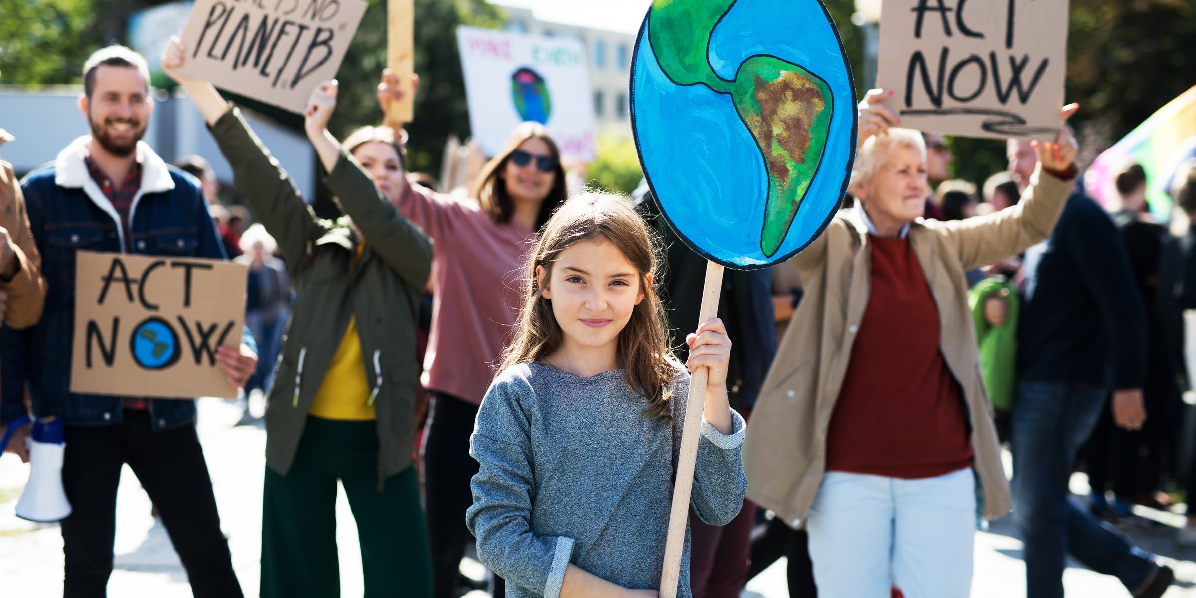 Zu früh am Limit - handeln am Earth Overshoot Day Mädchen hält Abbildung der Erde auf einer Klima-Demo in die Luft
